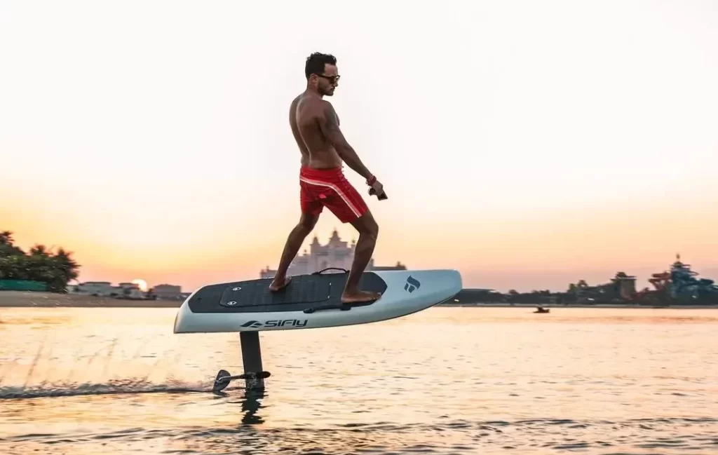 Men using electric surfboard on the sea.